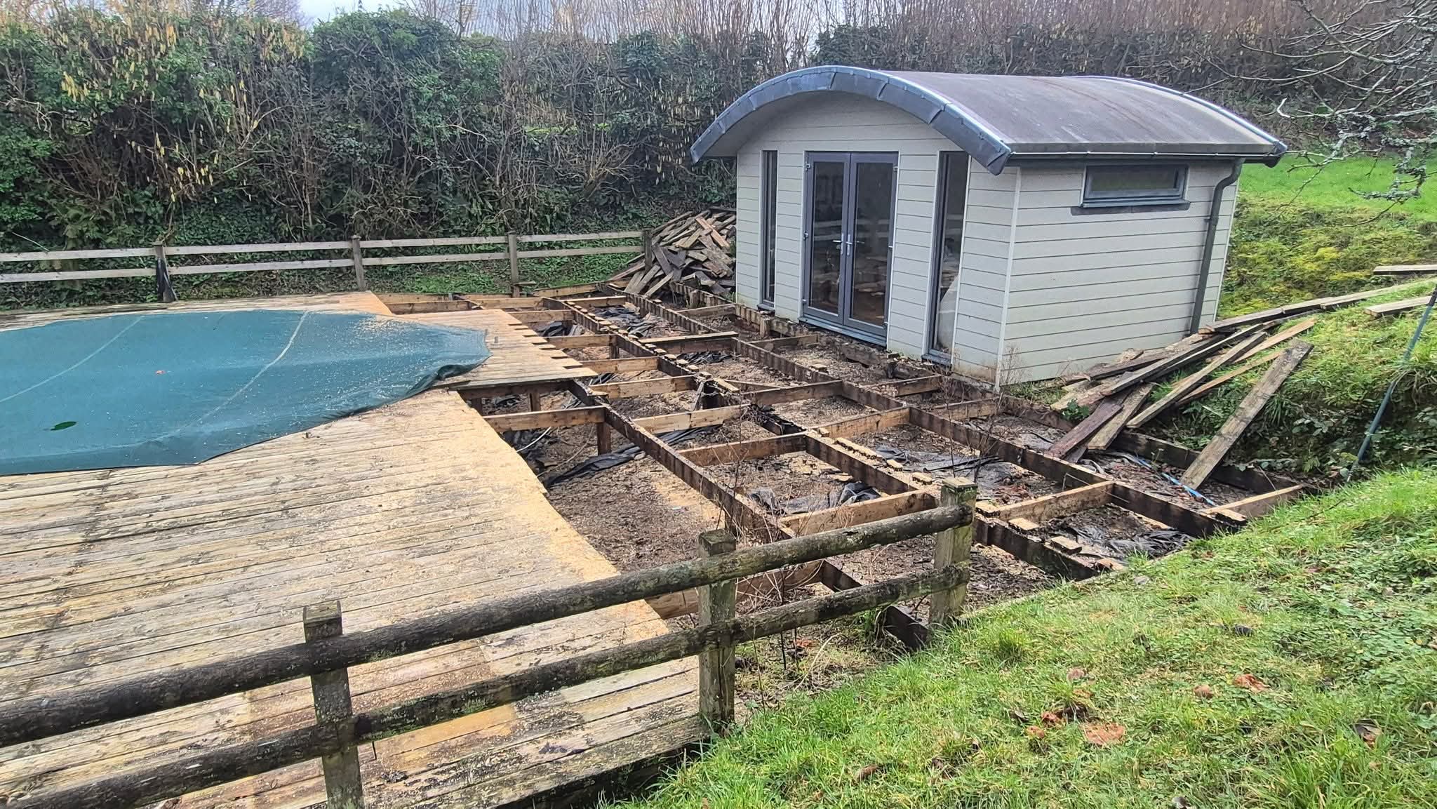 Old deck partially demolished showing the rotten substructure