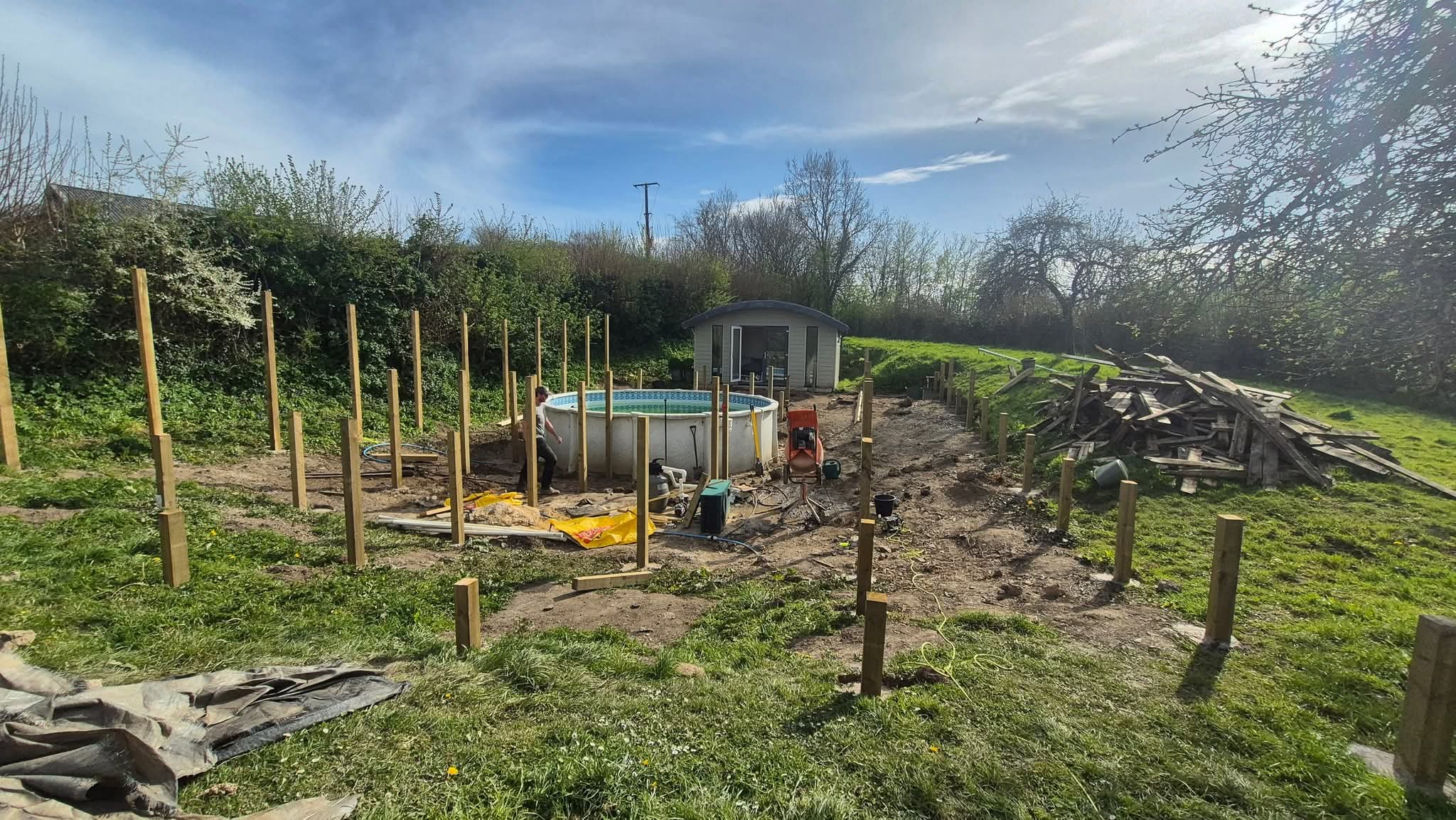 New treated timber posts set into the ground around the pool