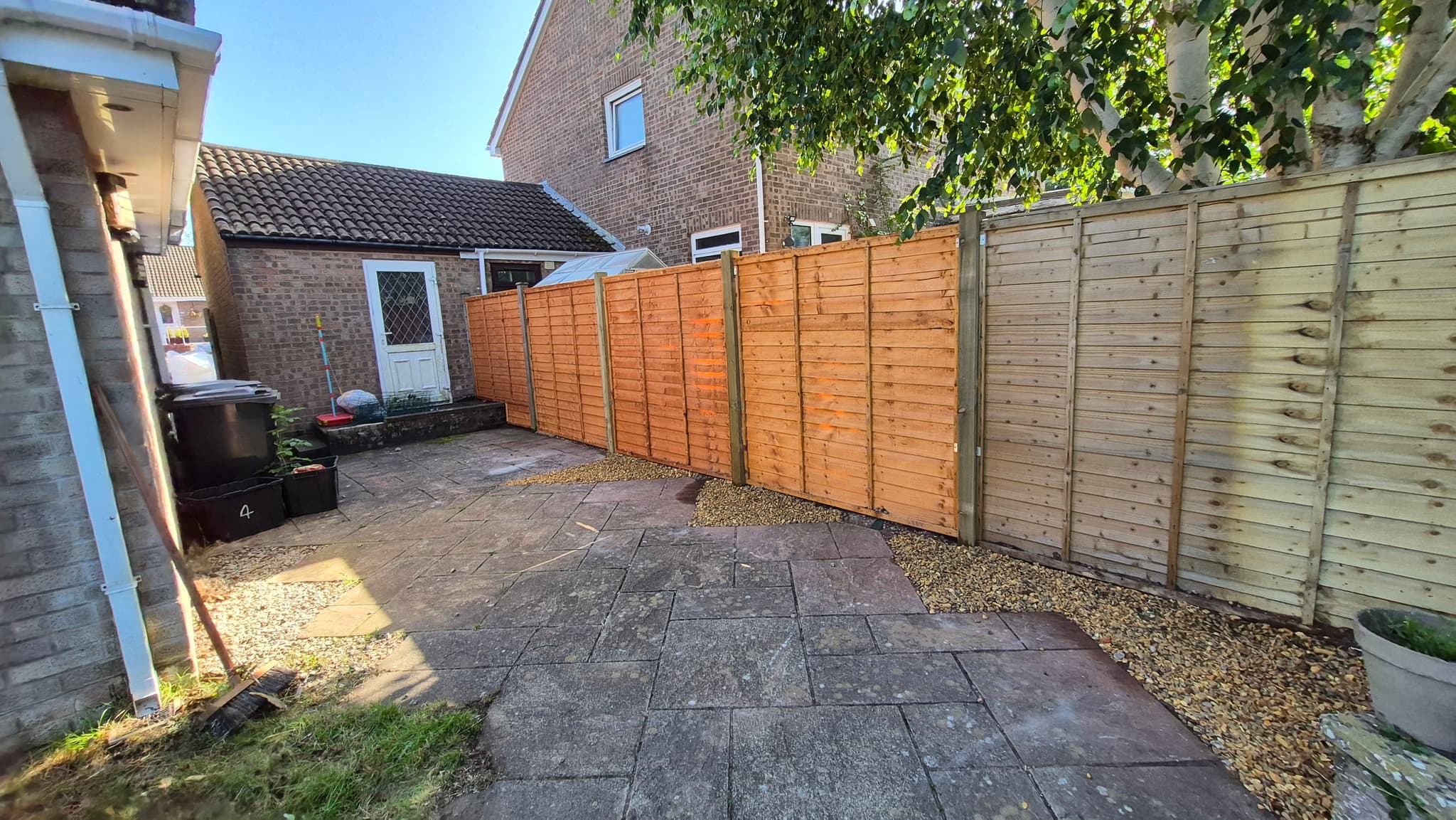 A long run of new fence panels along a boundary