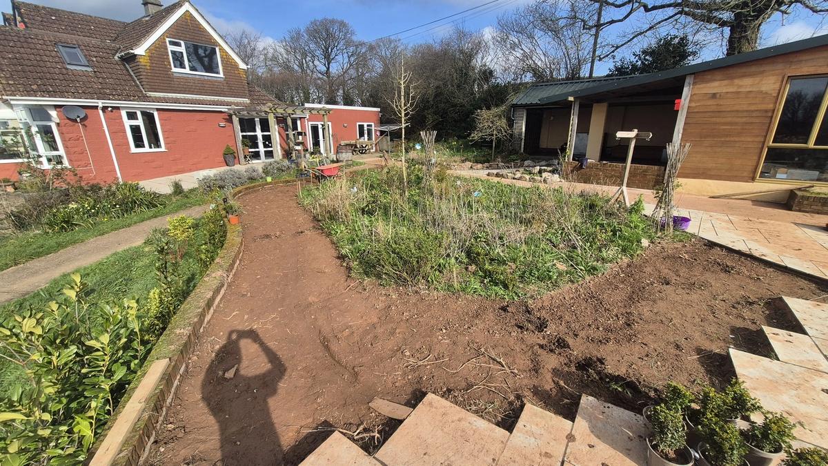 Curved path route dug out with red Devon soil