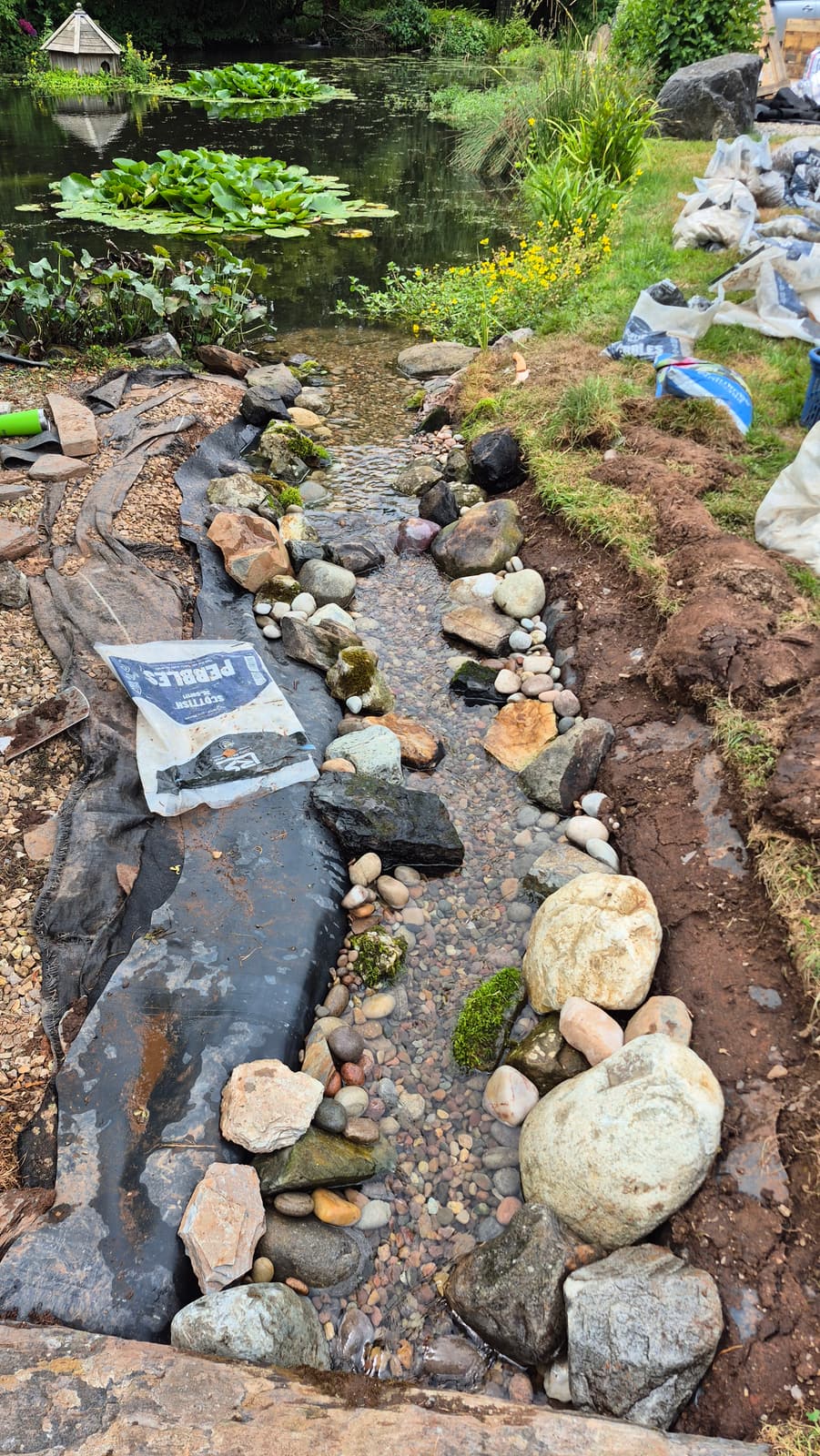 The fresh pebble bed and re-laid stone running down the length of the channel
