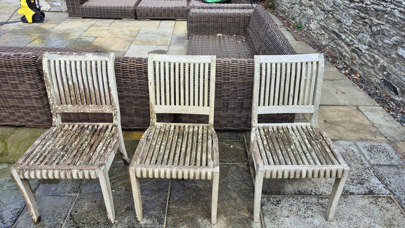Weathered grey teak garden chairs covered in lichen before restoration
