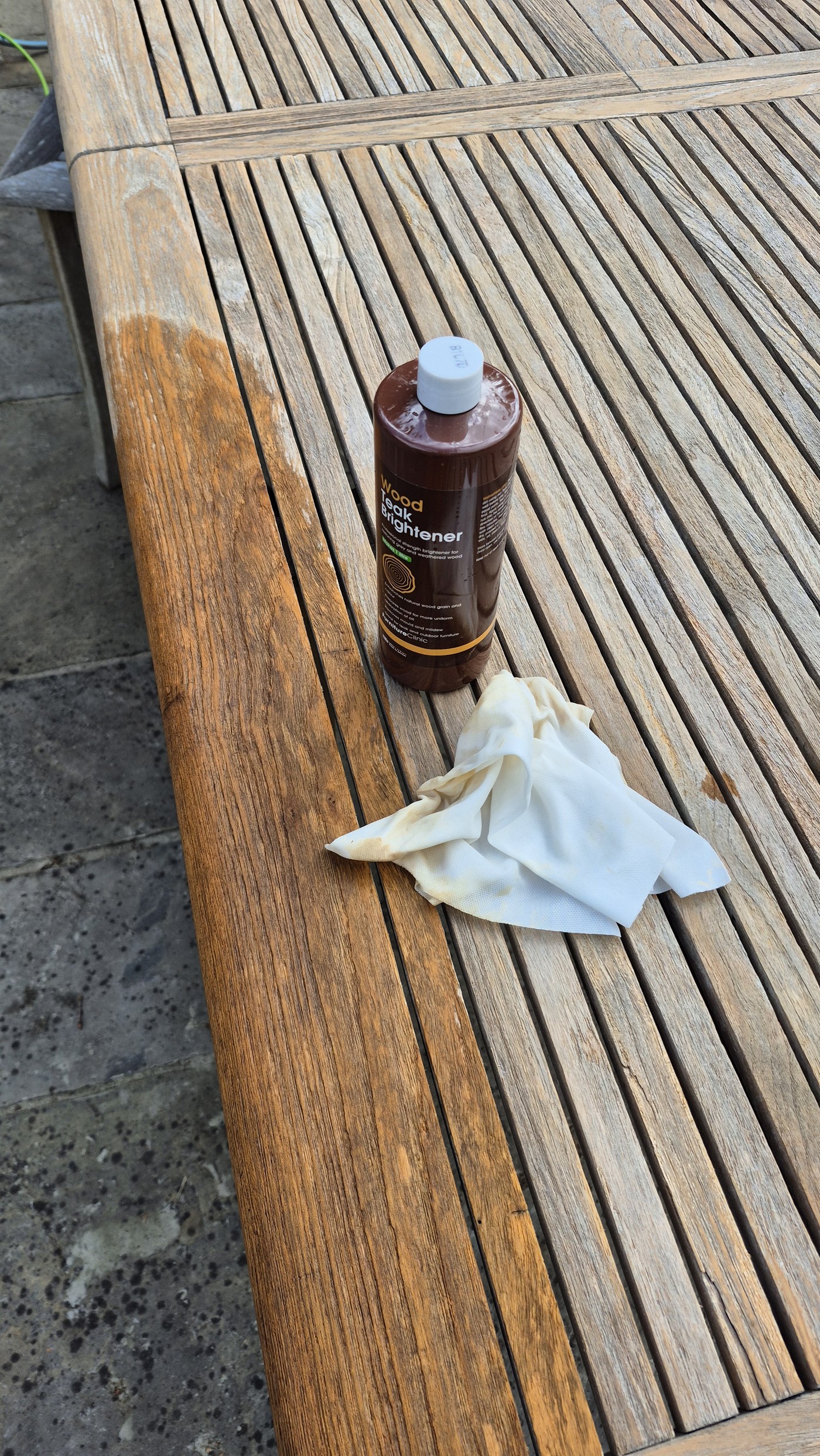 Teak table showing the contrast between treated and untreated sections with teak brightener