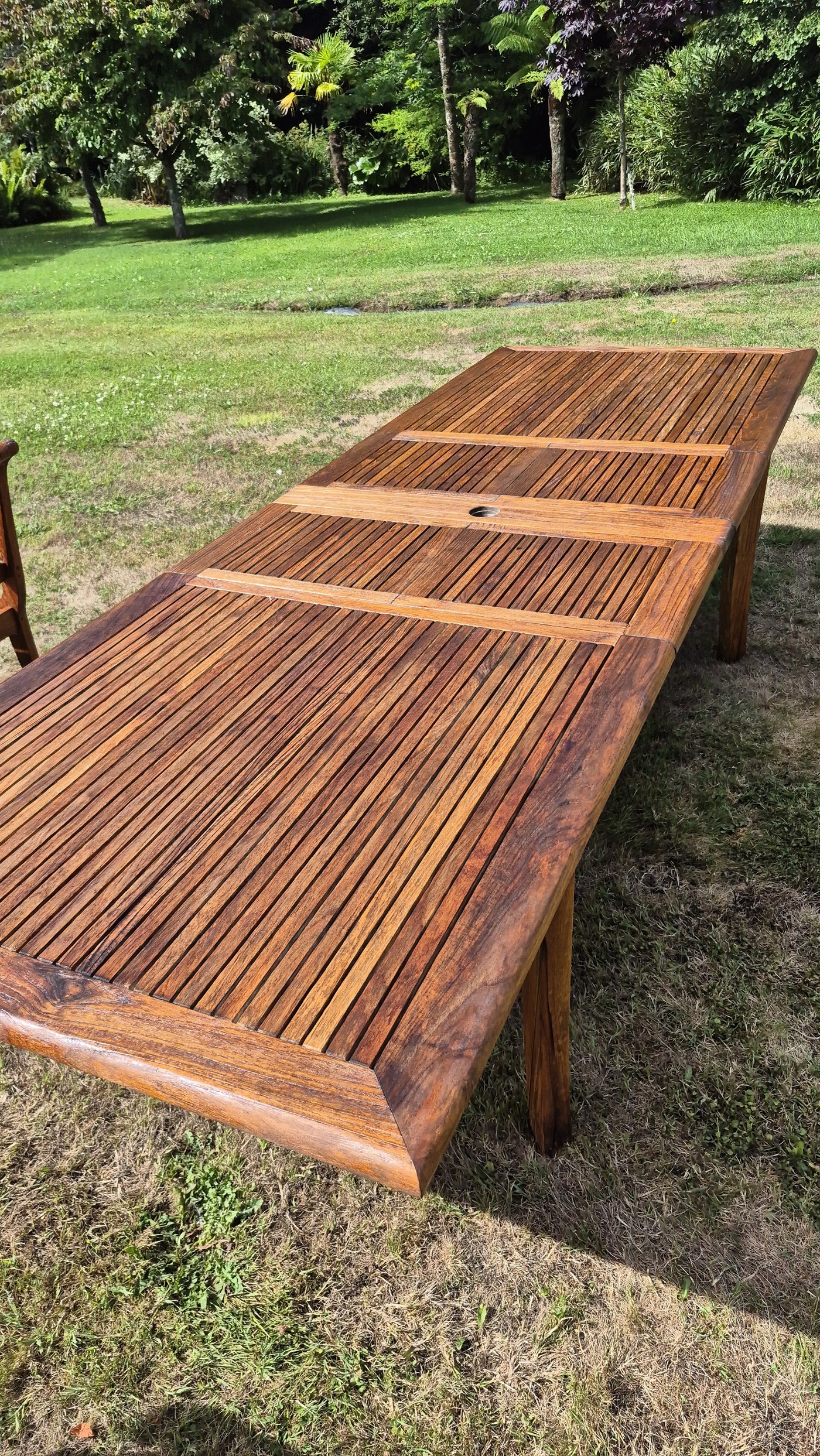 Fully restored teak table drying on the lawn showing deep golden colour