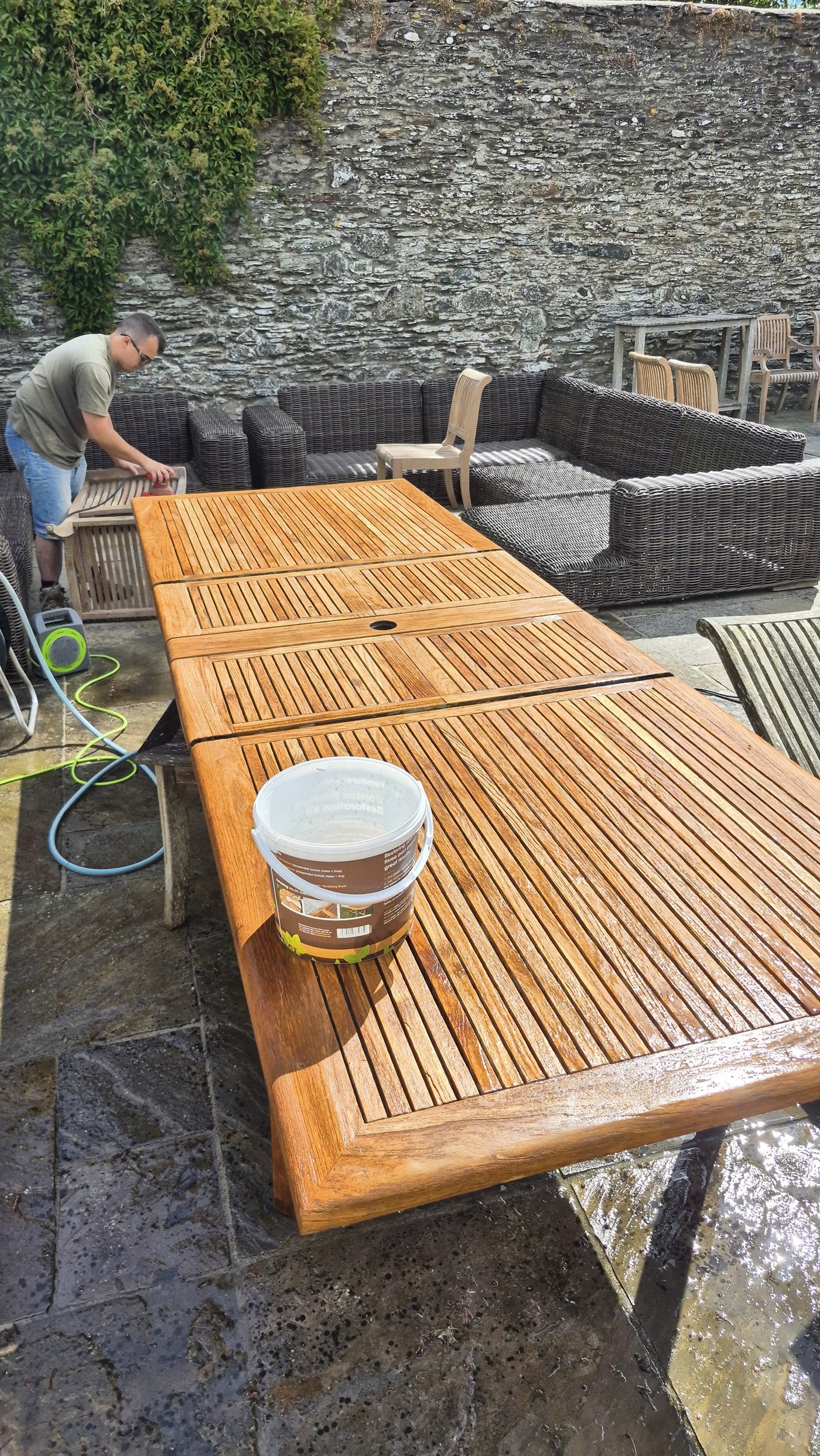 Teak table fully oiled showing rich golden colour on the patio